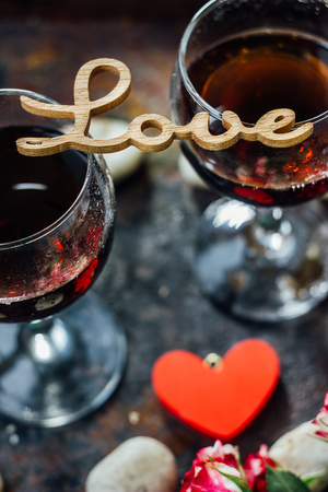 Glasses of Valentine's day wine with the letters LOVE, flowers and heartsの写真素材