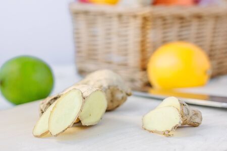 Ginger slices over wooden table with fresh fruitsの写真素材