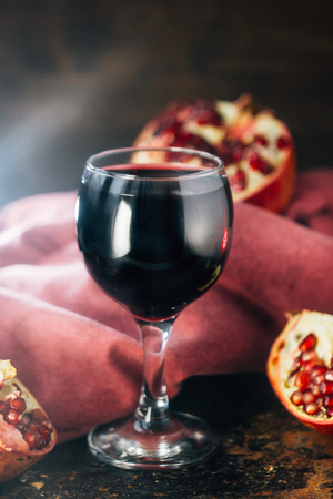 Fresh pomegranate juice in glass over black backgroundの写真素材