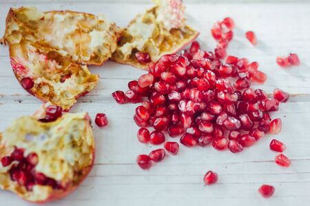 Pomegranate peel and seeds over white wooden backgroundの写真素材