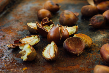 Peeled roasted chestnuts on black rustic surface.の写真素材