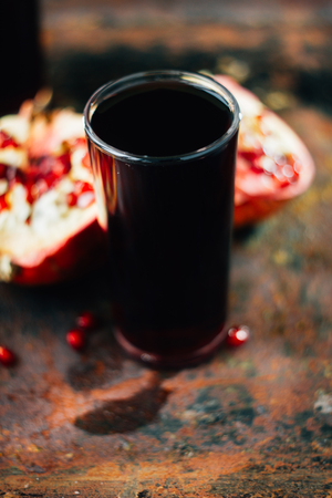Fresh organic pomegranate juice on rusty surfaceの写真素材