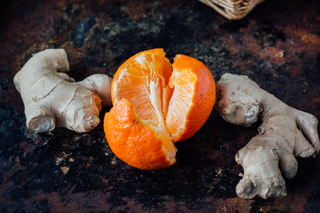 Ginger root with orange on black rustic surface.の写真素材