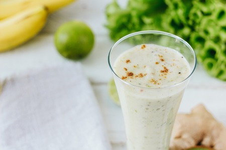 Fresh smothie - vegan drink with banana, salad leaves, ginger and kiwiの写真素材