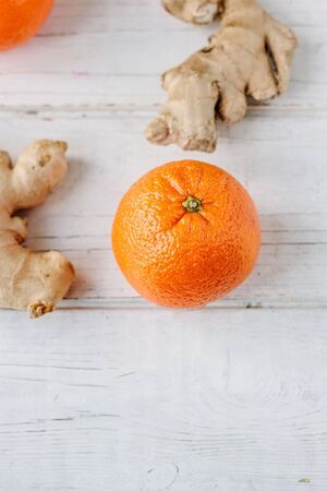 organic orange and ginger root on white surface.の写真素材
