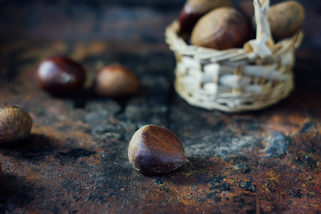Fresh chestnuts in basket over black rustic surfaceの写真素材