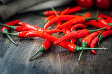 Red hot chili peppers over rustic wooden tableの写真素材
