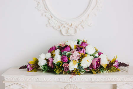 Bouquet of flowers over white fireplace in classic interior.の写真素材