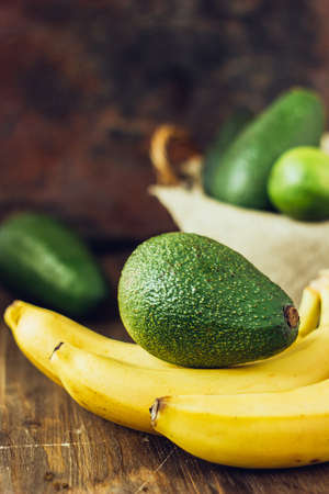 Avocado and banana over brown wooden backgroundの写真素材