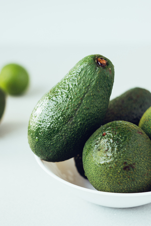 Fresh organic avocado in white ceramic bowlの写真素材