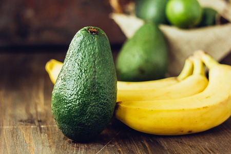 Avocado and banana over brown wooden backgroundの写真素材