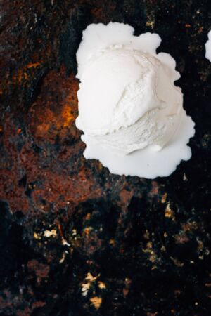 Ball of melted ice cream on black rustic surfaceの写真素材