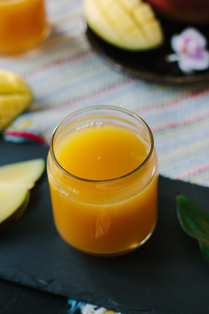 Orange and mango fruit juice over black slate.の写真素材