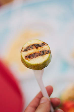 Grilled vegetables on a plastic fork at cafe.の写真素材