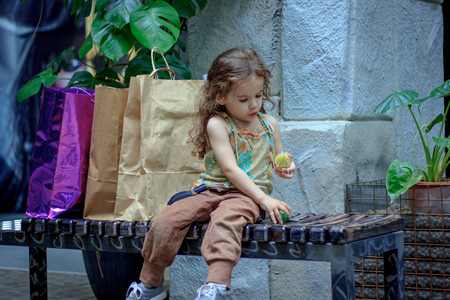 Adorable little girl at the market with shopping bags.の写真素材