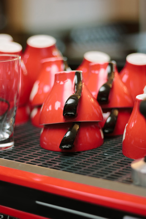Red coffee cups over the coffee machineの写真素材