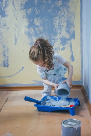 Little girl holding canister with paint at her room, making renovation.の写真素材