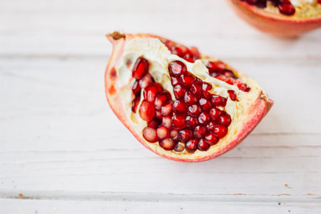 Pomegranate fruit over white wooden backgroundの写真素材