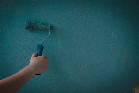 Painting wall by aqua color paints with paint roll.の写真素材