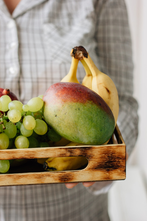 Woman holding box with fruits in hands.の写真素材