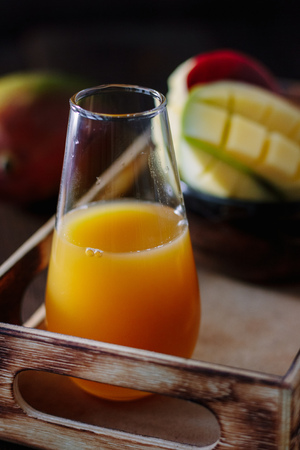 Glass with fresh mango juice in wooden boxの写真素材