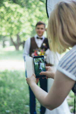 Photographing wedding couple by the smartphoneの写真素材