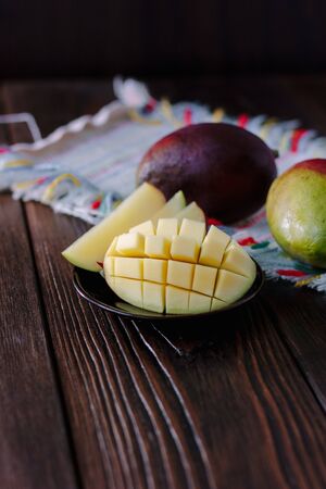 Mango cutted for cubes over wooden tableの写真素材