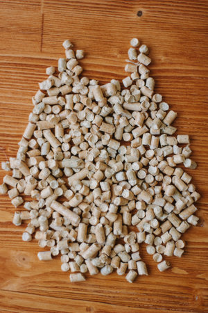 Biofuel - small wooden pellets over the wooden table.