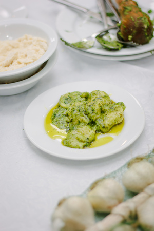 Italian food - ravioli with fresh pesto sauce in a white ceramic plate.の写真素材