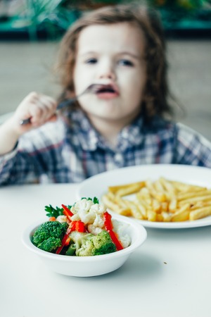 Kid in a restaurant and healthy food.の写真素材