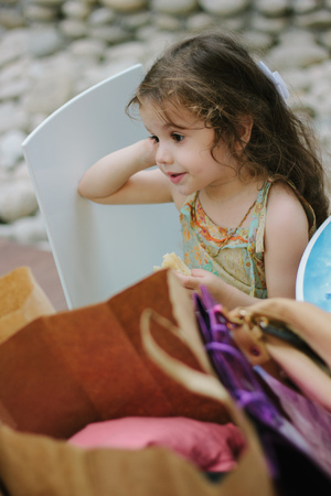 Little girl tired from shopping and sitting with the shopping bags.の写真素材