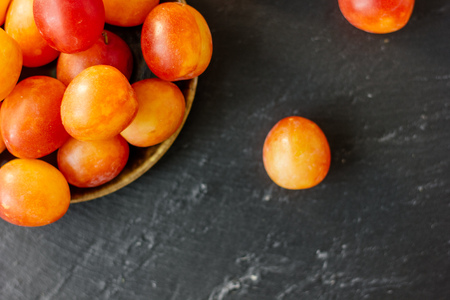 Top view of wild plums fruits on black stone background.の写真素材