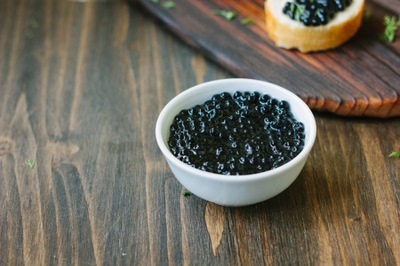 Fresh black caviar in a white ceramic bowlの写真素材