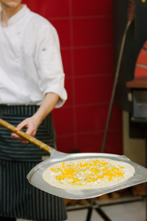 Uncooked pizza on the pizza shovel on the italian restaurant kitchenの写真素材
