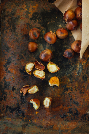 Peeled roasted chestnuts on black rustic surface.の写真素材
