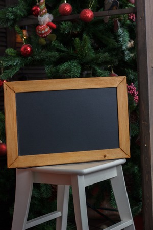 Nice black board on winter decoration - christmas tree as background.の写真素材