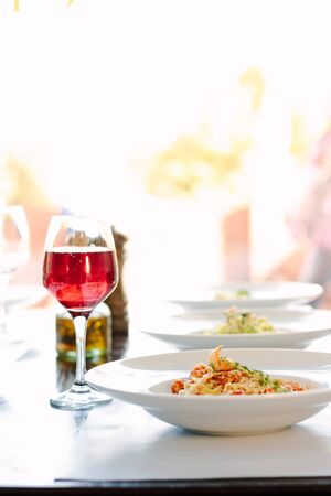 Table in a italian restaurant served with italian pasta.の写真素材