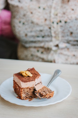 Woman eating small cake in a restaurant.の写真素材