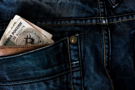 Jeans pocket with leather wallet and russian roubles with bitcoin coin.の写真素材