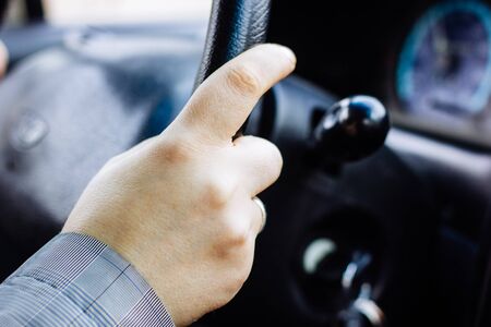 Hand holding car steering wheel during driving.の写真素材