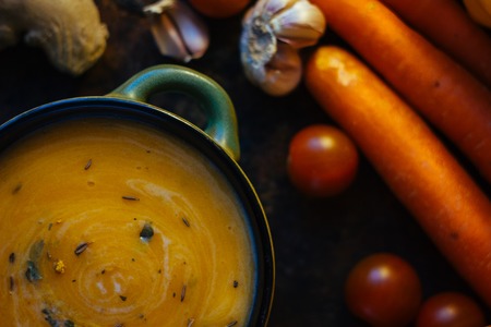 Delicious soup with ginger and vegetables on black surface.の写真素材