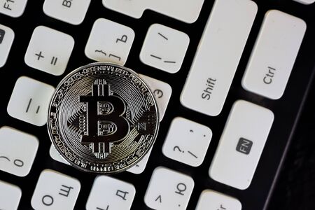 Bitcoin currency coin on white computer keyboard.の写真素材