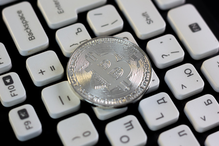 Bitcoin currency coin on white computer keyboard.の写真素材
