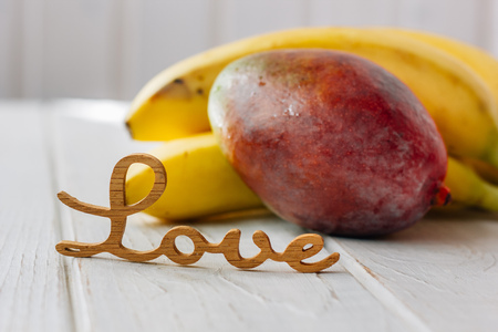 Tropical fruits with word Love on white table.の写真素材