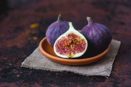 Fig fruits on clay plate on dark background.の写真素材