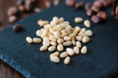 Clean pine nuts on black kitchen board.の写真素材