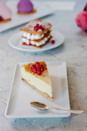 Cheesecake with red currant berries on white plate.の写真素材