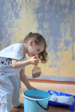 Little kid having fun with paint brush, helping renovating walls by color paints.の写真素材