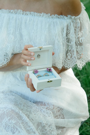 Nice wedding rings in a box in bride hands.
