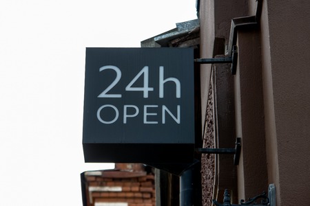 24 hours open signboard on a street on wall of store or resraurantの写真素材